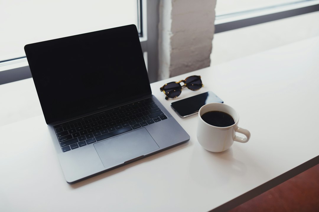 Scrivania elegante con laptop, tazza e occhiali per Business English